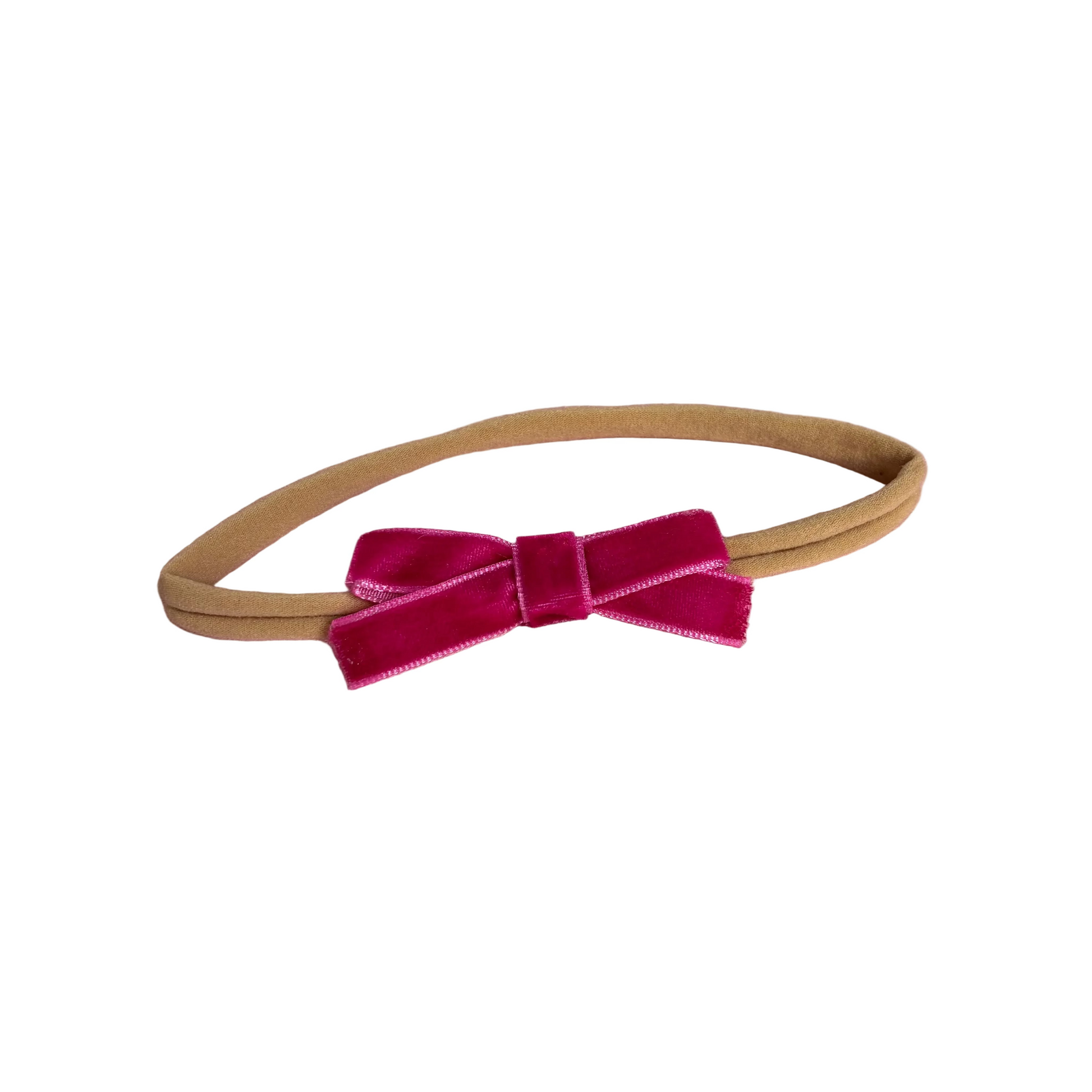 Beige headband with a pink velvet bow on a white background