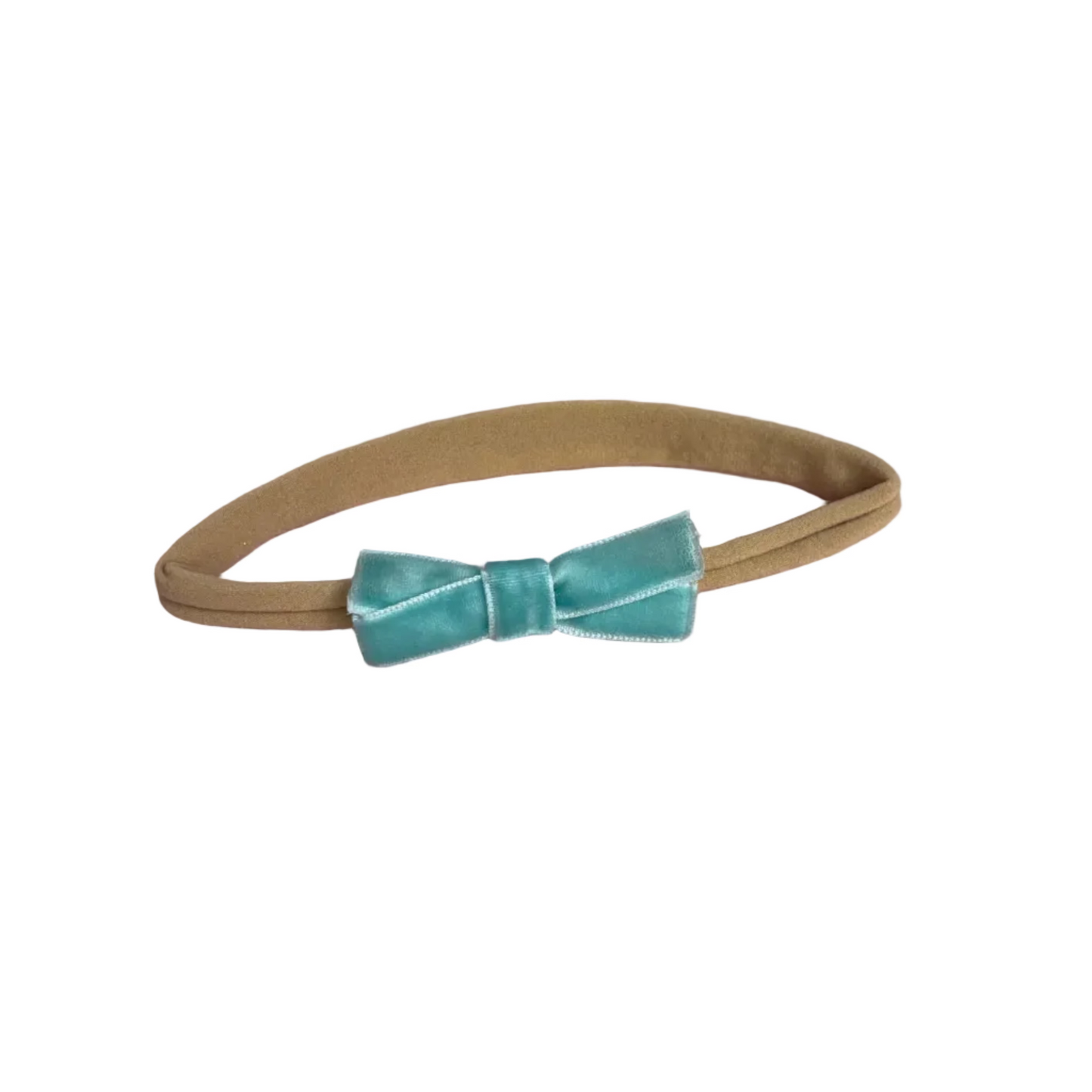 Beige headband with a turquoise velvet bow on a white background