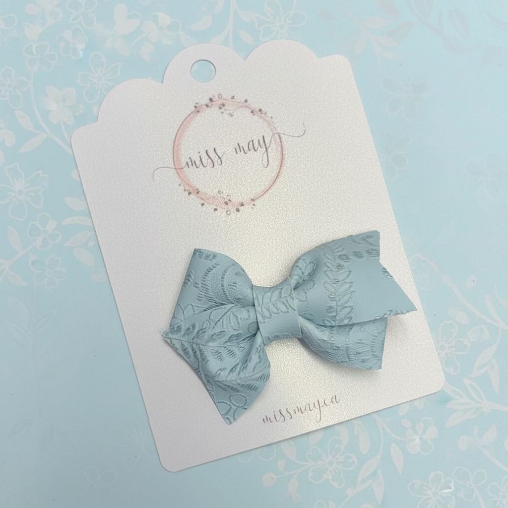 Soft blue embossed faux leather bow hair clip, stylish neutral kids hair accessory for everyday wear